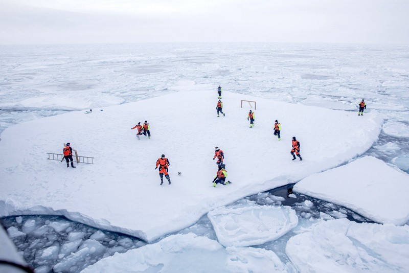 Norwegian Navy privates and scientists from Norwegian Institute of Marine Research, play soccer on an ice floe around Greenland